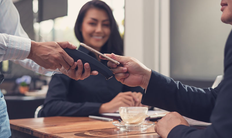 A businessman pays with his mobile phone