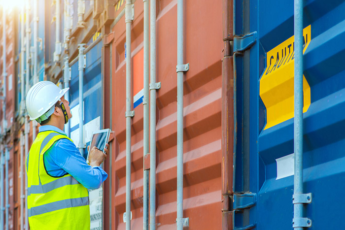 A worker checks on some trade containers.