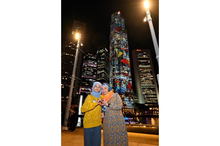 /Beneficiaries in front of the UOB Plaza projection mapping show.