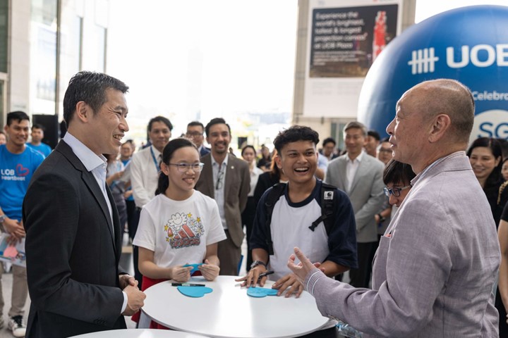 /Mr. David Neo and Mr. Wee Ee Cheong warmly interacting with two young beneficiaries.